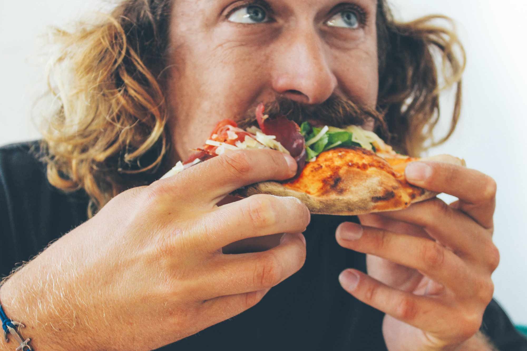 Man eating a pizza in the Cafeteria Stellingen