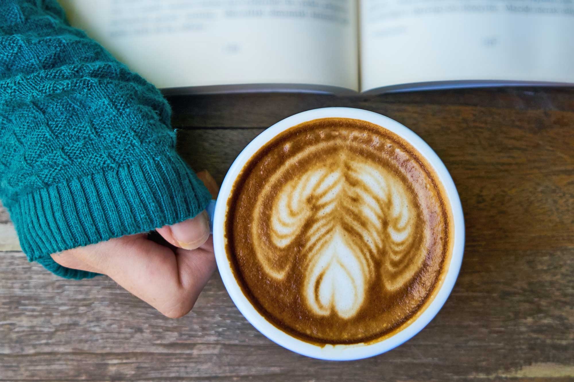 Woman holding a cup of cappuccino in her hand