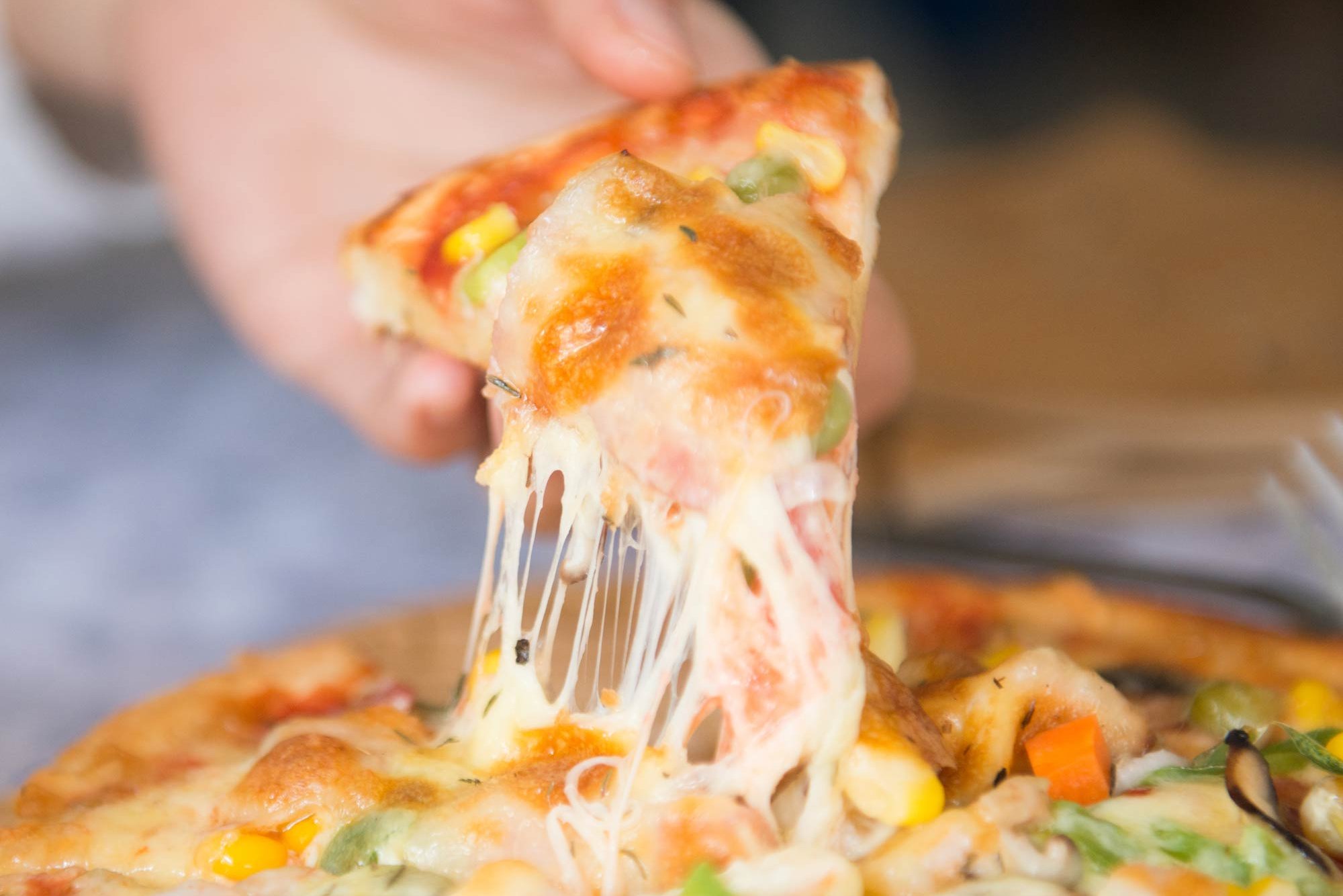 slice of pizza in hand