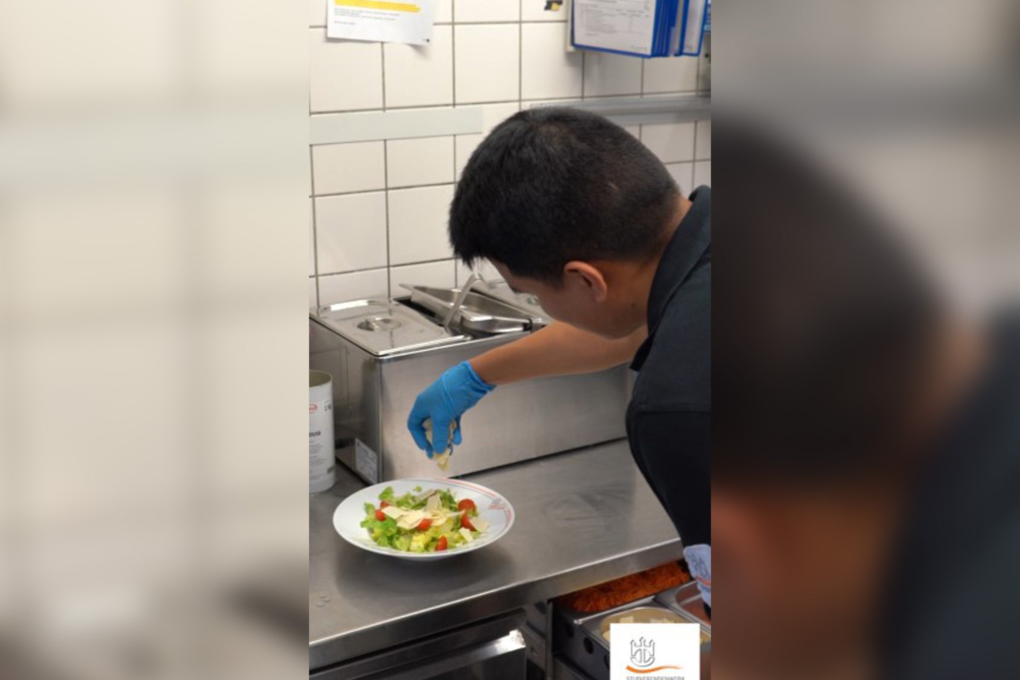 Auszubildender zur Fachkraft Küche beim Anrichten eines Tellers