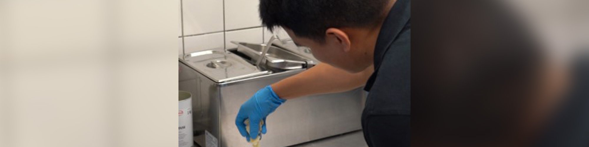 Auszubildender zur Fachkraft Küche beim Anrichten eines Tellers