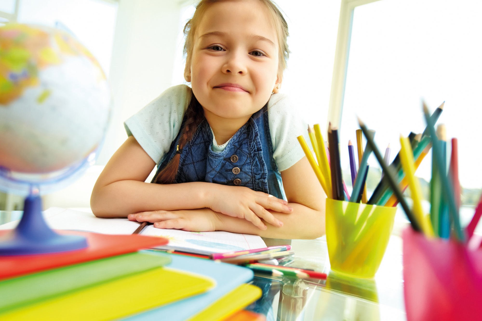 Mädchen sitzt an einem Tisch in der Vorschule