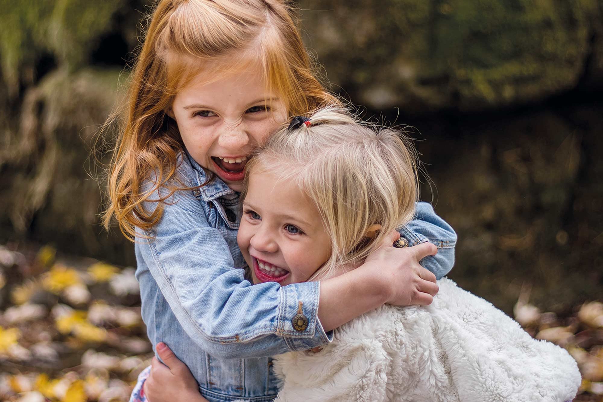 Two girls hugging and laughing