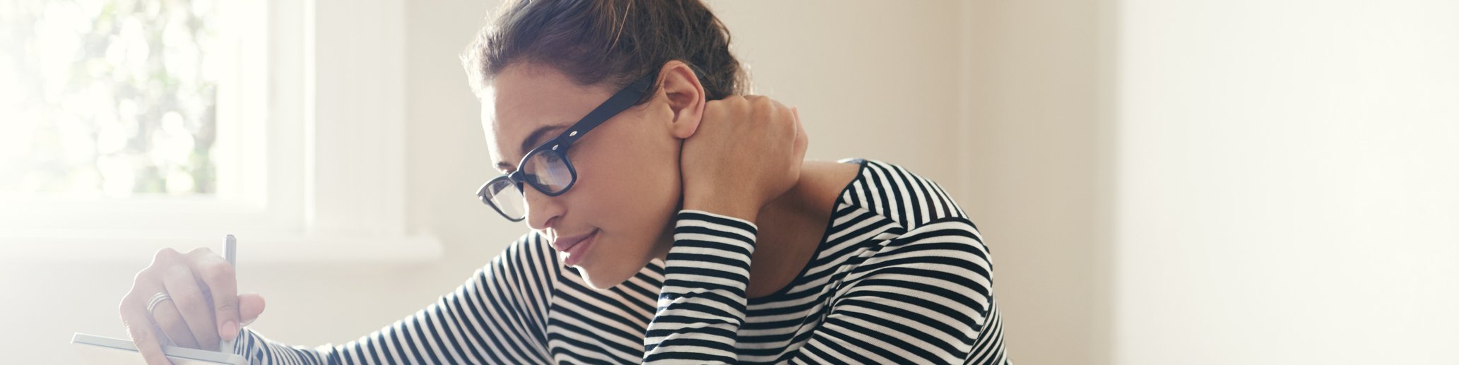 Woman sitting at a table in front of a tablet