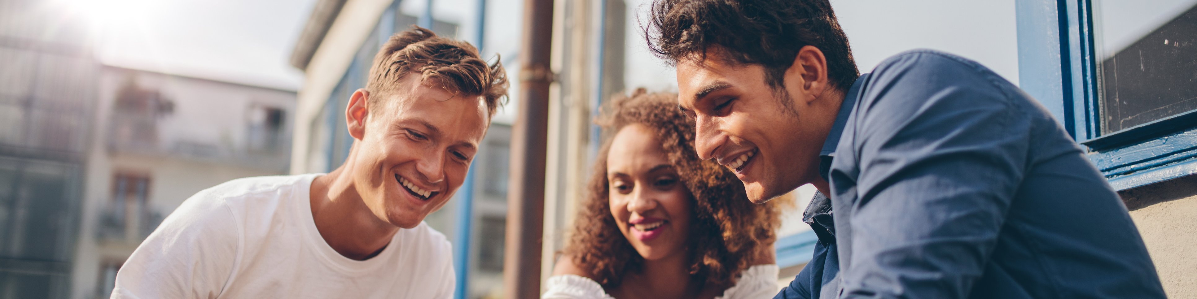 Three young people looking at a cell phone together