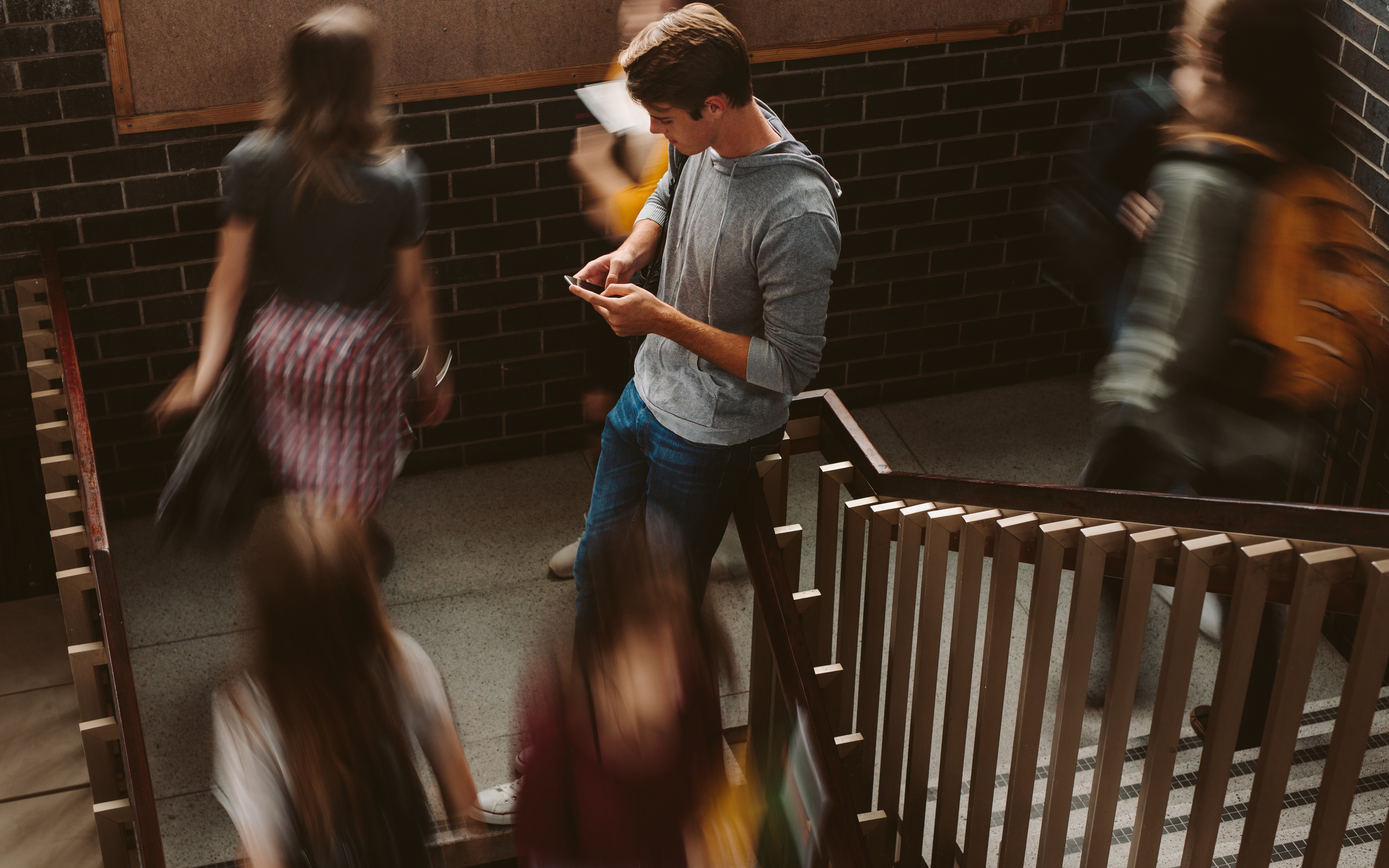 Student lehnend am Treppengeländer