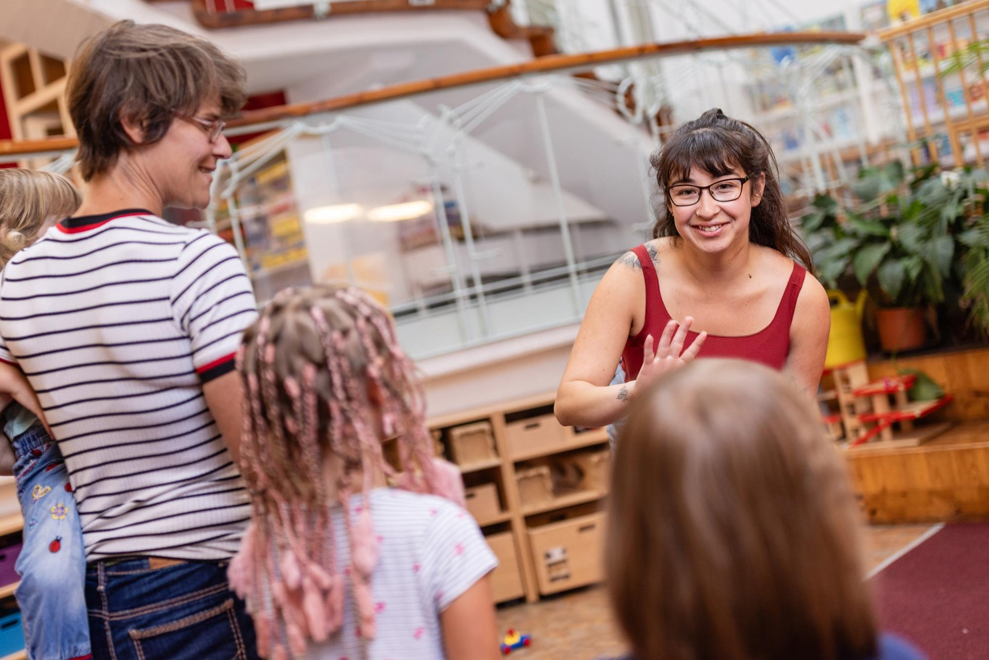 [Translate to Englisch:] Zwei Erzieher:innen sprechen mit zwei Kindergartenkindern