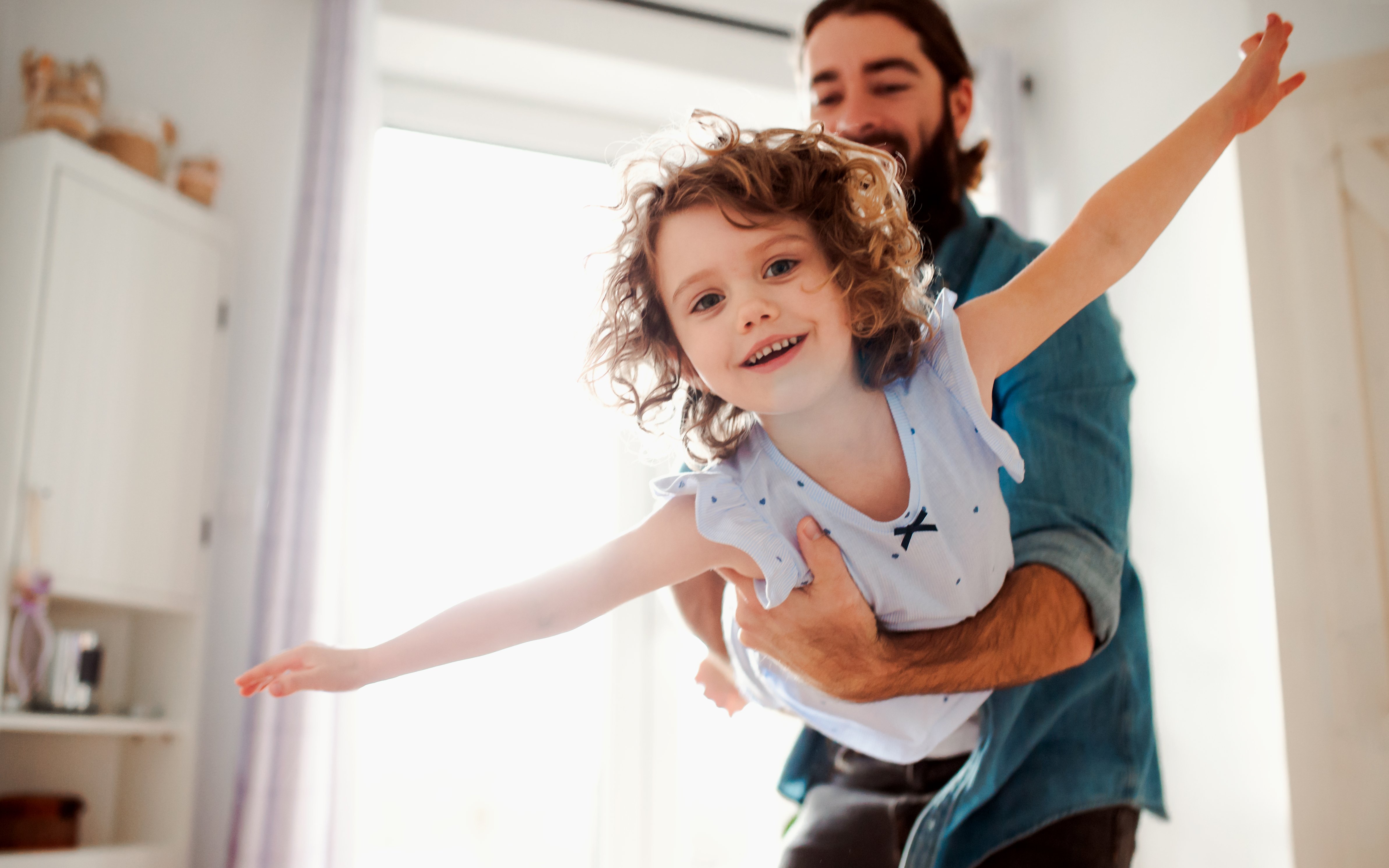 Mann spielt mit kleinem Kind auf dem Arm