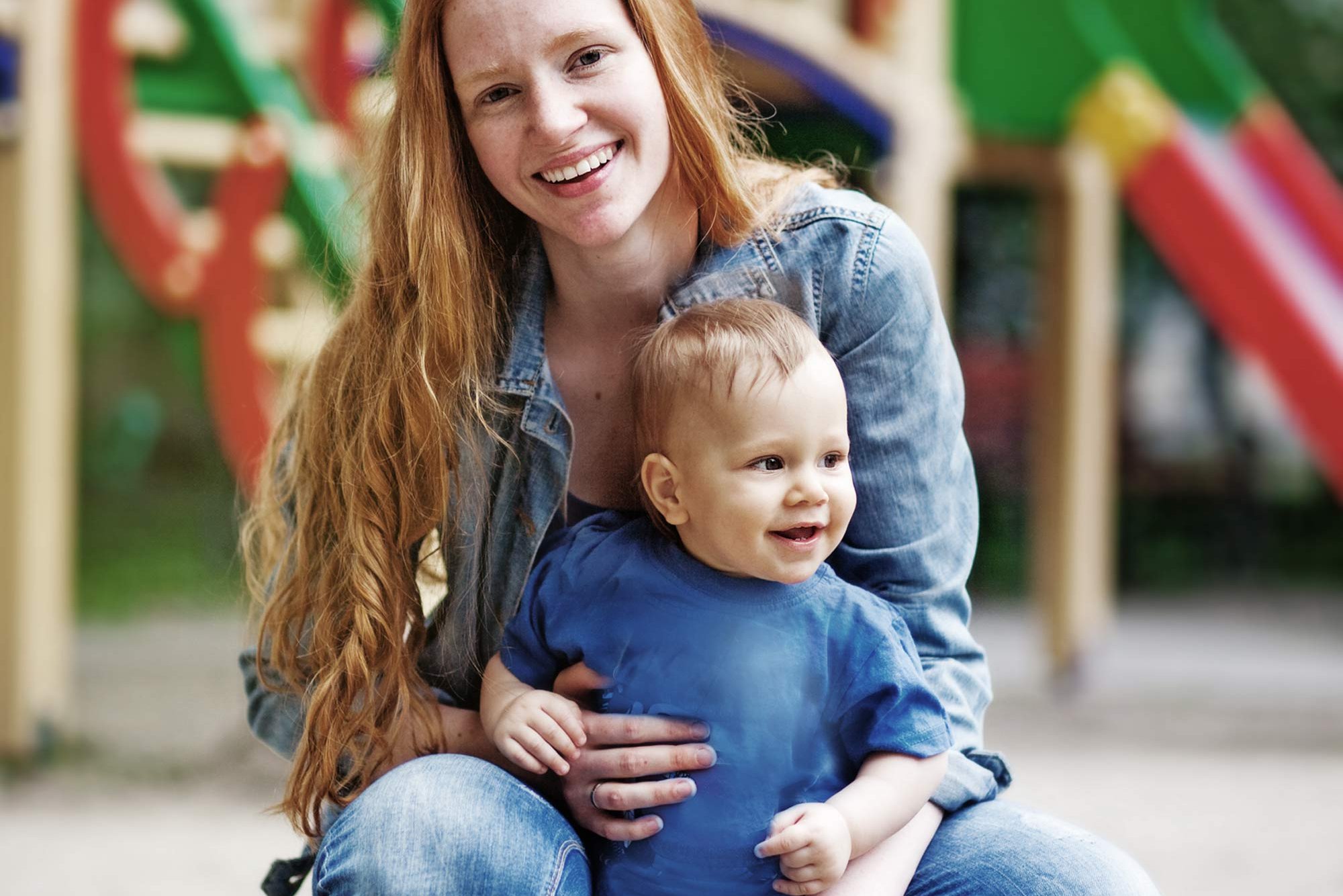 Teacher with a small child at the playground of the Bornstraße daycare center