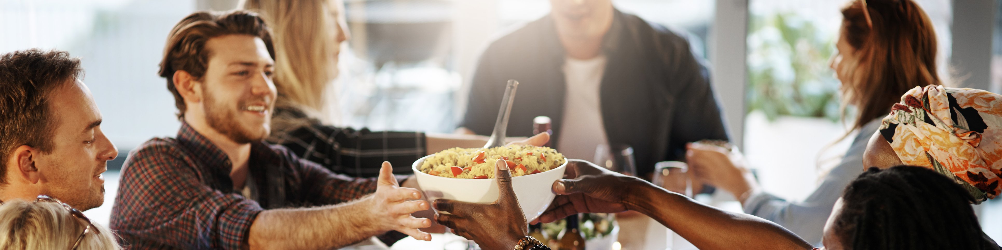 Gruppe junger Menschen an einer festlichen Tafel mit Essen