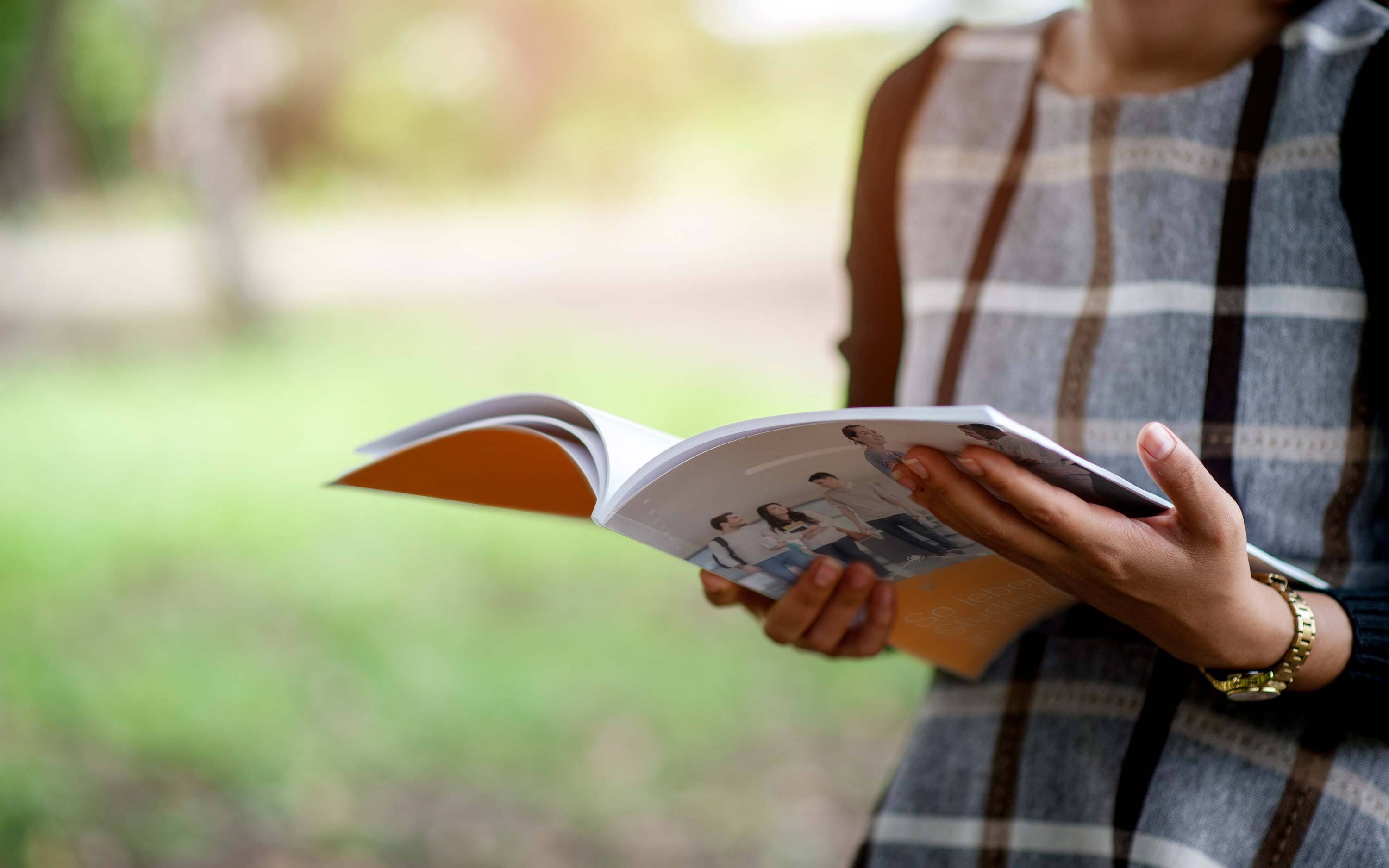 Frau hält die Sozialerhebung in der Hand